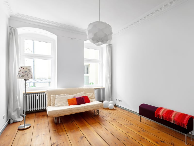 Vacant period property in Kreuzberg 61 featuring stucco details, wooden floorboards, and a view of greenery